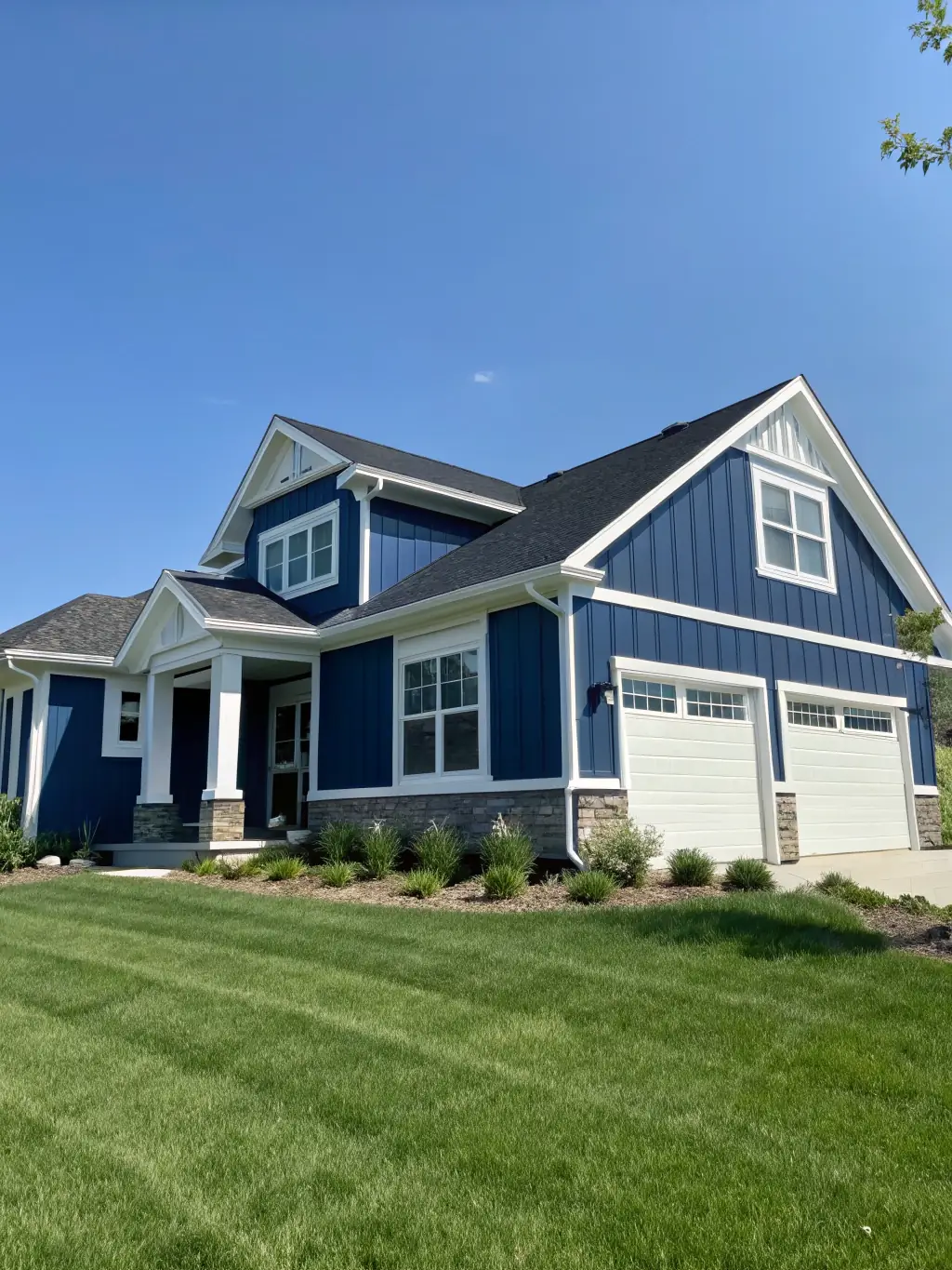 A well-maintained house exterior with newly painted siding in a neutral color, complemented by a vibrant front door, illustrating the quality of DBR Painting LLC's exterior painting service.